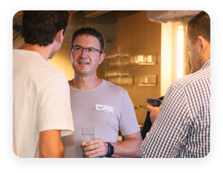 Two guests talking over drinks at a Hello Clever partner event